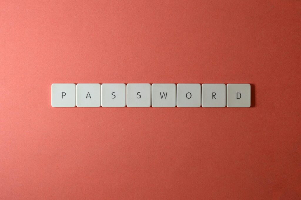 White keyboard keys spelling “PASSWORD” on a coral background, representing small business password security and safer login management.