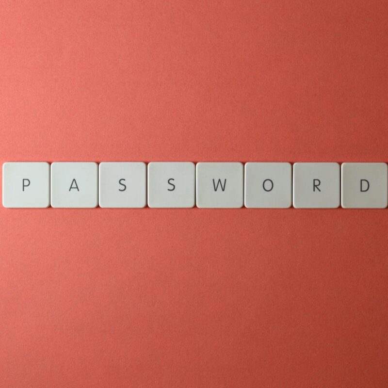White keyboard keys spelling “PASSWORD” on a coral background, representing small business password security and safer login management.